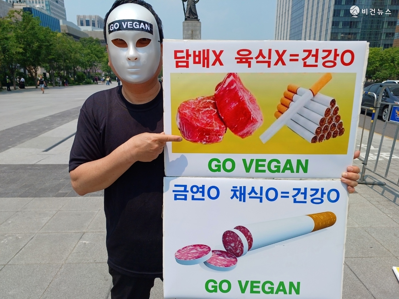 27일 서울 광화문광장에서 열린 기자회견에서 참가자가 육식과 흡연의 위험성을 알리는 피켓을 들고 있다. (사진=한국채식연합 제공)