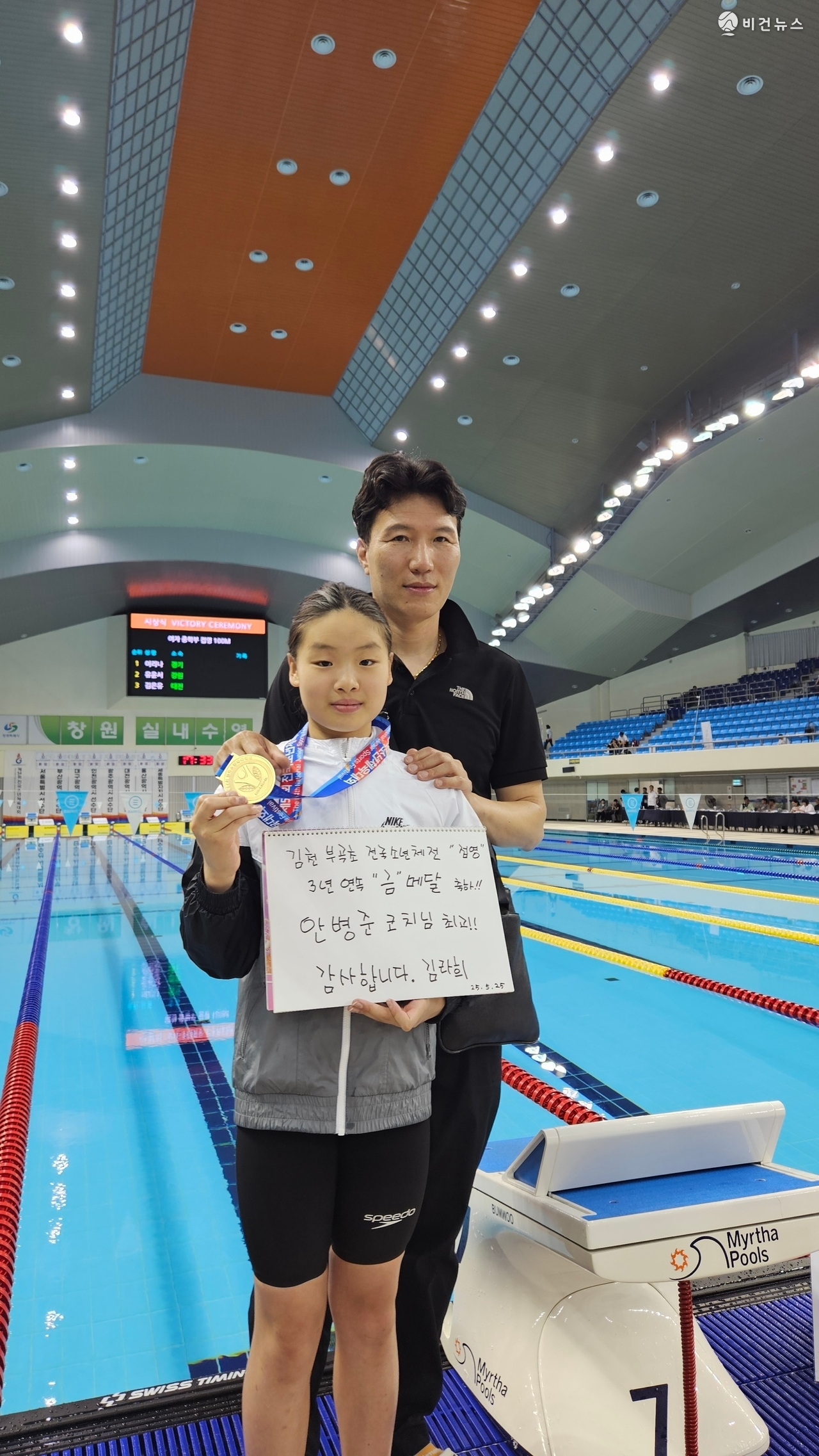 제54회 전국소년체육대회 수영 여초부 접영 100m 금메달을 딴 김천부곡초 김라희 선수가 지도자인 안병준 코치와 함께 기념 촬영을 하고 있다. (사진=김천교육지원청 제공)