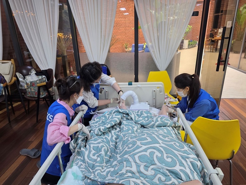 바디코스플러스 전문 케어팀이 요양병원 병실에서 고령 환자의 손발을 위생적으로 관리하고 있다. (사진=바디코스플러스 제공)