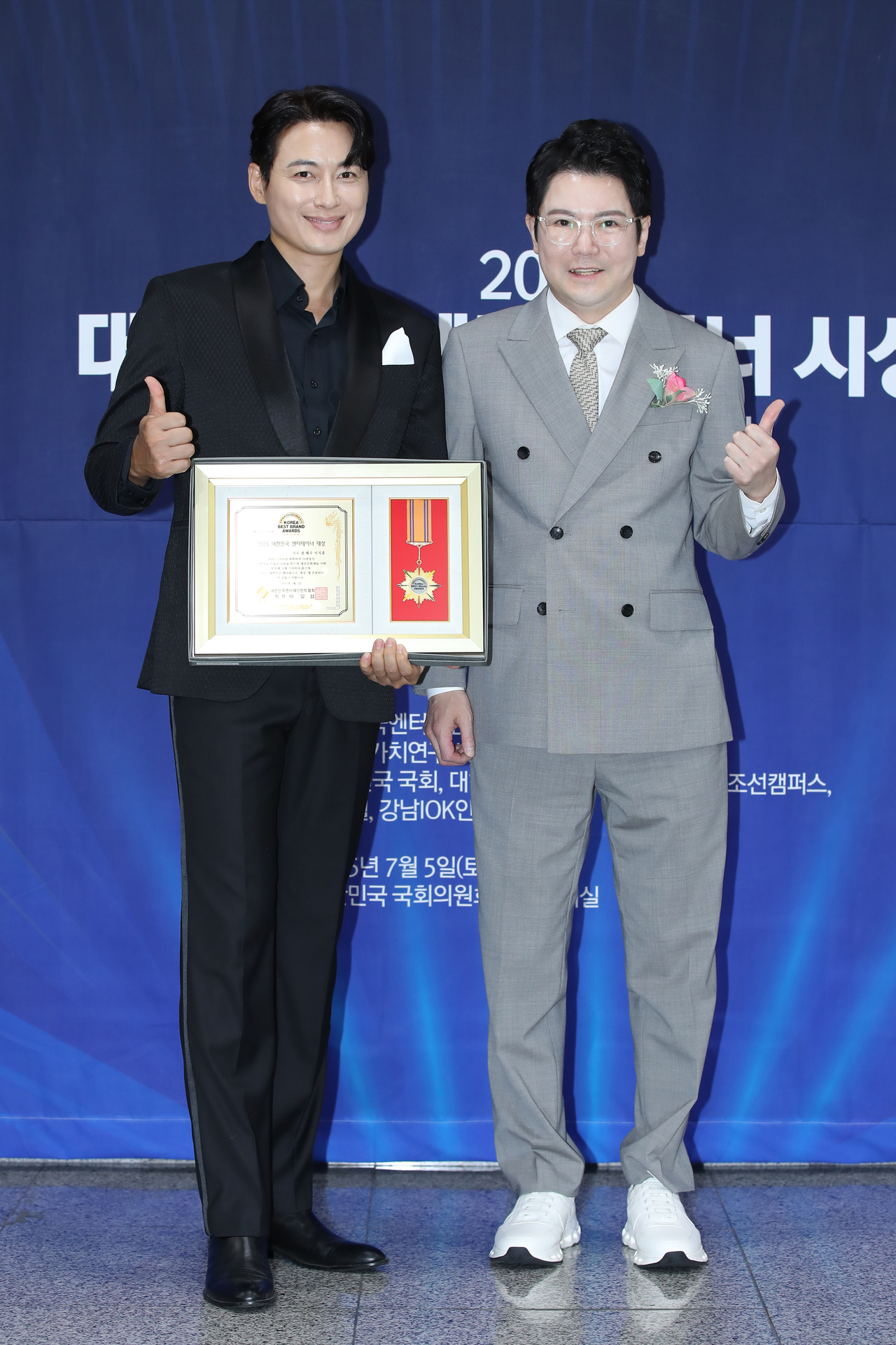 가수 겸 배우 이지훈(왼쪽)과 대한민국엔터테인먼트협회 이일섭 회장이 지난 7월 5일 국회의사당 의원회관 대회의실에서 열린 ‘제24회 대한민국 베스트브랜드어워즈’ 시상식에서 국회교육위원장 표창 수상 후 기념촬영을 하고 있다. (사진=대한민국엔터테인먼트협회 제공)