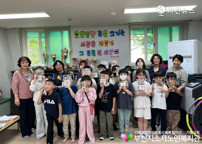 도담지역아동센터에 방문하여 아이들과 단체사진을 촬영하고 있다.