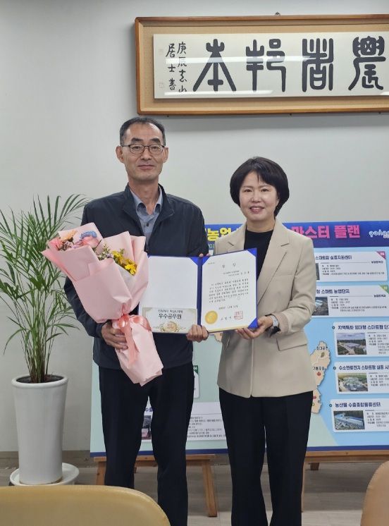 이현주 농업기술센터 소장이 9월 민원처리 단축 마일리지제 우수공무원 김정훈 주무관에게 시상하고 있다.