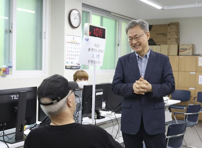 장인홍 구로구청장이 민생회복 소비쿠폰 신청 대기 중인 어르신과 인사를 나누고 있다.