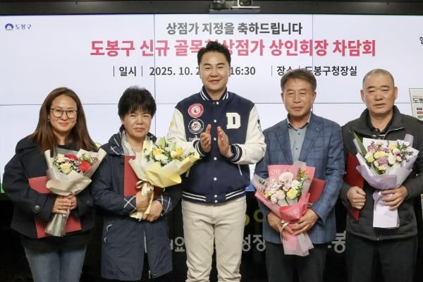 오언석 도봉구청장(가운데)과 이번에 새로 신규 지정된 골목형상점가 상인회장이 신규 지정을 기념하며 단체 사진을 찍고 있다